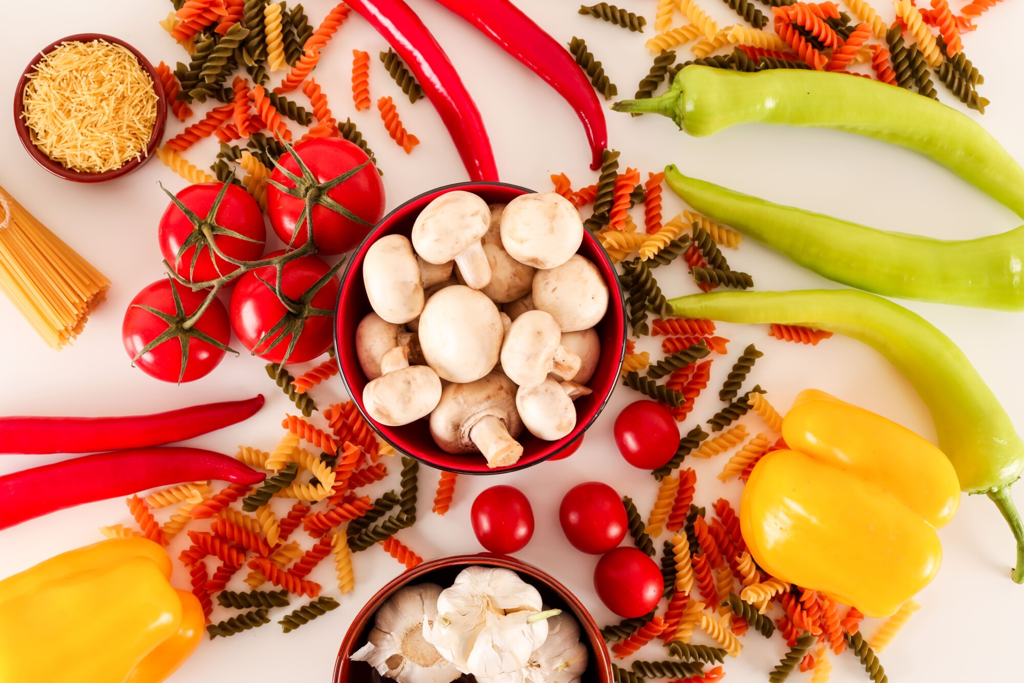 fresh-vegetables-colorful-pasta-with-mushroom-garlic-pepper-white-surface (1)